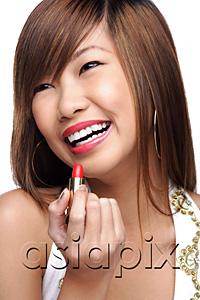 AsiaPix - Young woman holding lipstick