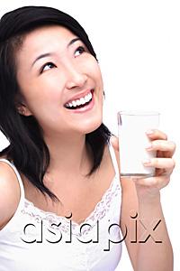 AsiaPix - Young woman with glass of milk, looking up