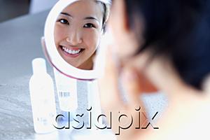 AsiaPix - Young woman looking in mirror, over the shoulder view