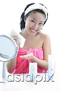 AsiaPix - Young woman sitting at dressing table, smiling at camera