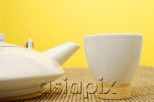 AsiaPix - Still life with Chinese teacup and teapot, against yellow wall