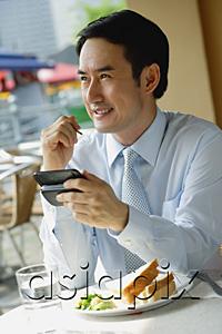 AsiaPix - Businessman in cafe, using PDA, smiling