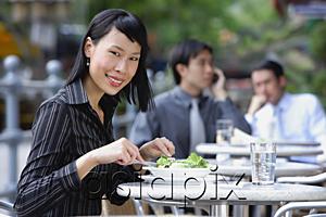 AsiaPix - Business people at outdoor cafÃ©, focus on woman in foreground, having a salad