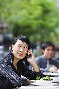 AsiaPix - Businesswoman using mobile phone at outdoor cafe