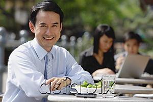 AsiaPix - Businessman at outdoor cafe, smiling at camera