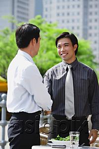 AsiaPix - Businessman at outdoor cafe, shaking hands