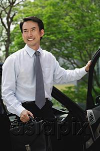 AsiaPix - Businessman getting out of car, carrying briefcase