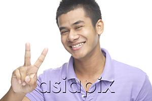 AsiaPix - Man smiling at camera, making peace hand sign