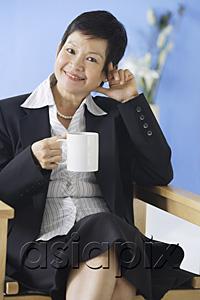 AsiaPix - Business woman sitting on chair, holding mug