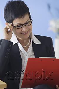 AsiaPix - Business woman reading clipboard
