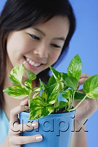 AsiaPix - Young woman with houseplant