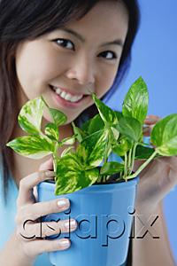 AsiaPix - Young woman holding houseplant