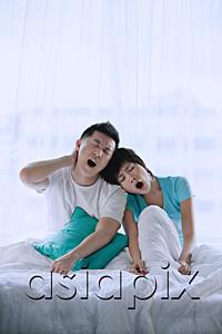 AsiaPix - Couple sitting on bed, yawning