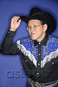 AsiaPix - Senior man dressed in cowboy attire, adjusting hat