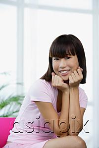 AsiaPix - Young woman dressed in pink, sitting on pink chair, hands on chin