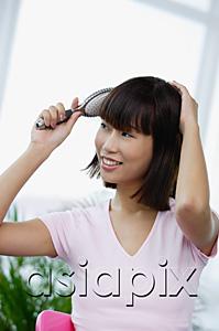 AsiaPix - Young woman brushing her hair