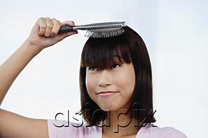 AsiaPix - Young woman brushing her hair