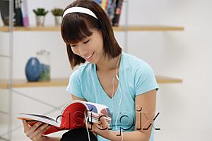 AsiaPix - Young woman looking through magazine