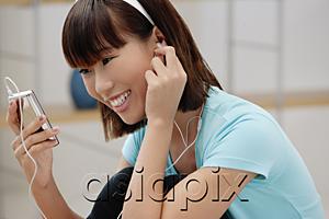 AsiaPix - Young woman listening to MP3 player