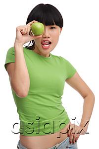 AsiaPix - Young woman in green T-shirt, holding green apple