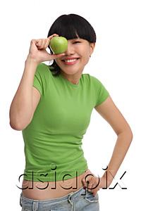 AsiaPix - Young woman in green T-shirt with green apple