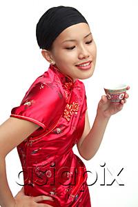 AsiaPix - Young woman in cheongsam holding Chinese teacup