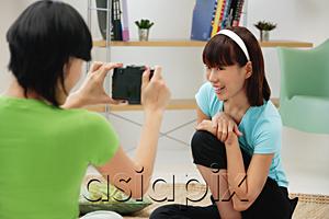 AsiaPix - Young woman taking a picture of another young woman
