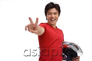 AsiaPix - Young man carrying helmet, making peace sign