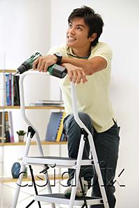 AsiaPix - Man leaning on stepladder, holding drill