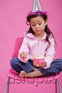 AsiaPix - Girl with party hat, holding bowl of cake, looking sad