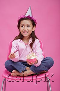 AsiaPix - Girl with party hat, sitting on chair, holding bowl of cake