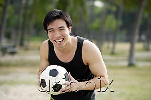 AsiaPix - Man holding soccer ball, smiling