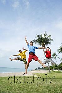 AsiaPix - Three men  on beach, jumping in air, looking at camera