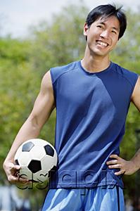 AsiaPix - Man holding soccer ball, looking at camera
