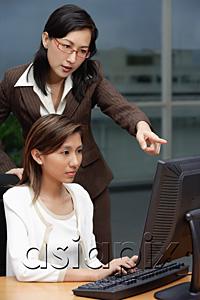 AsiaPix - Two businesswomen working together, looking at computer