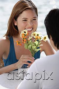AsiaPix - Couple sitting at outdoor cafe, woman holding flowers