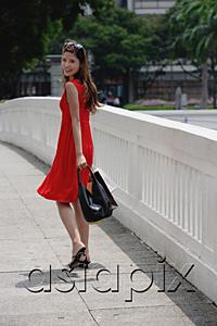 AsiaPix - Woman in red dress carrying shopping bags, looking over shoulder
