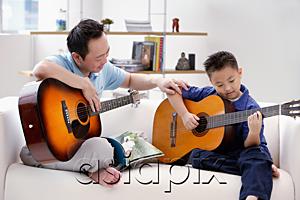 AsiaPix - Father teaching son to play the guitar