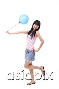 AsiaPix - Young woman holding a blue balloon, standing on one leg