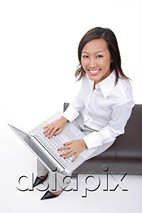 AsiaPix - Woman sitting on bench with laptop, smiling at camera