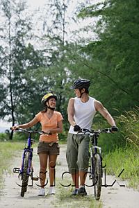 AsiaPix - Couple walking with bicycles, looking at each other