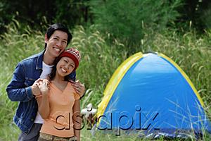 AsiaPix - Couple smiling at camera, tent in the background
