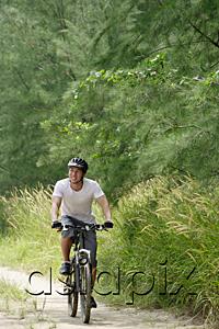 AsiaPix - Man cycling on nature path