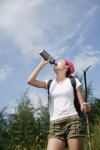 AsiaPix - Female hiker drinking from bottle, low angle view