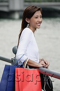 AsiaPix - Woman with shopping bags, standing by railing