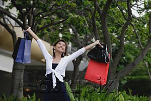 AsiaPix - Woman with shopping bags, arms outstretched, smiling