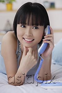 AsiaPix - Young woman using telephone, smiling