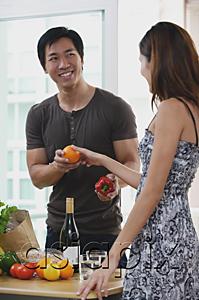 AsiaPix - Couple at home, woman passing man a fruit