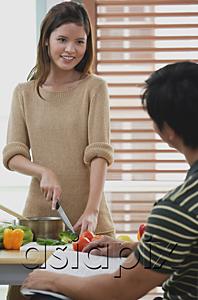 AsiaPix - Woman chopping vegetables, looking at man in front of her
