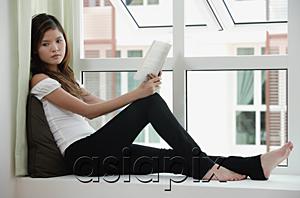 AsiaPix - Woman sitting on bay window holding a book